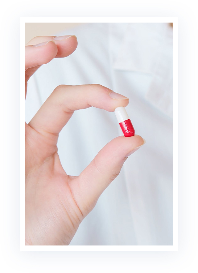 hand holding red and white pill